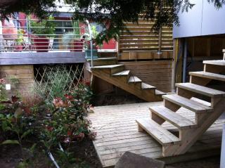 Terrasse et escalier bois avec garde-corps métallique.