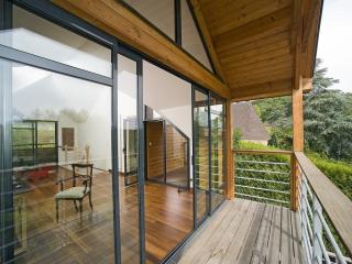 Terrasse bois avec garde-corps métallique et main courante bois.