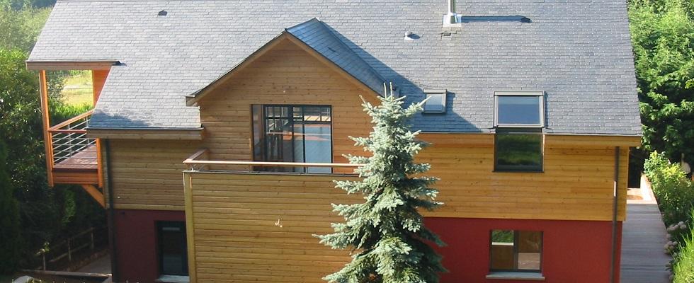 Surélévation en ossature bois, bardage en bois naturel, toiture double pente en ardoise, balcons.
