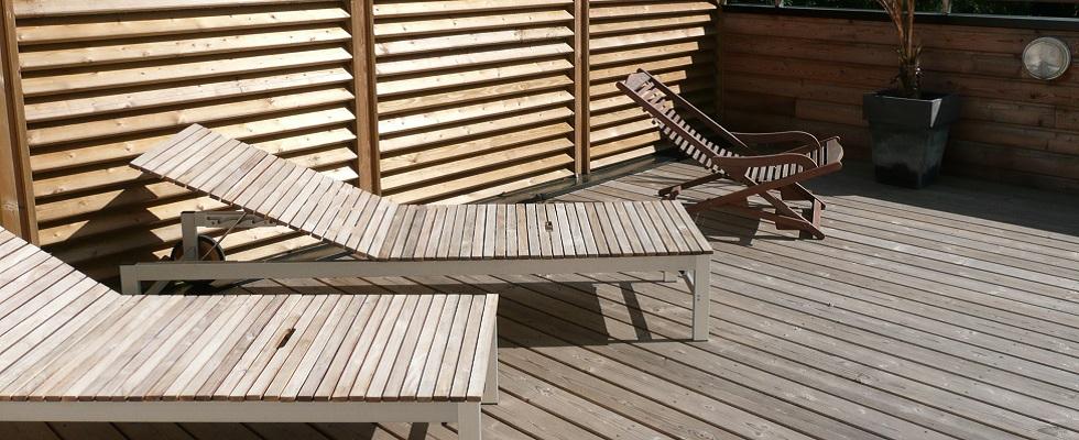 Terrasse, pare-vue en bois, transat en bois.